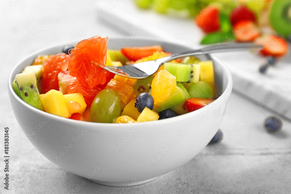 Wall mural Bowl of fresh fruit salad on table