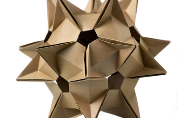 Close up on cardboard ornament. Intricate shape of figure, looking like a celestial body. Paper...