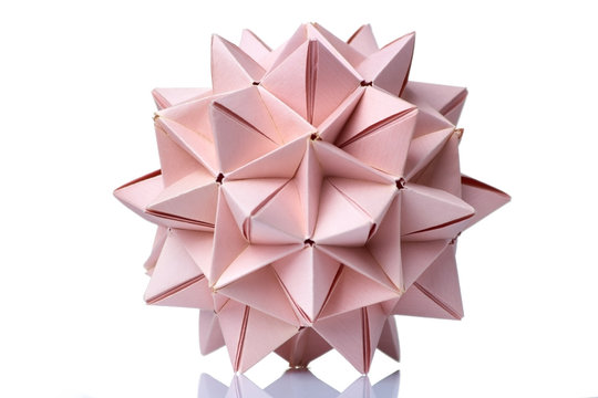 Spiky ball origami model. Wonderful figurine made of pink colored paper and assembled of many units.