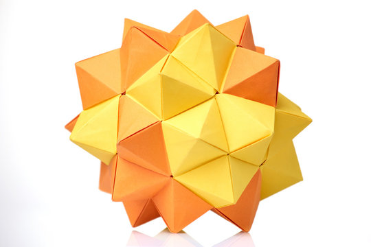 Modular origami model on white. Yellow and orange, 3D spiky ball. Visual art, geometry, paper folding.