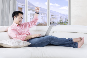 Fototapeta premium Success man with laptop on sofa