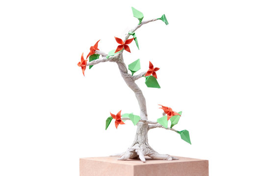 Handmade bonsai tree on white. Origami flowers and leaves on twisted trunk. Result of paper craft.