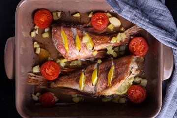 Red sea perch or red grouper with tomatoes and lemon baked and cooked. Top view