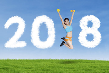 Sporty woman jumping with numbers 2018