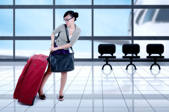Female entrepreneur pulling suitcase at the airport