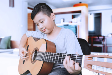 Cute boy playing acoustic guitar