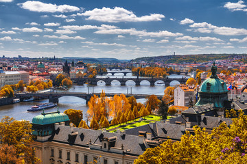 Fototapeta na wymiar View to the historical bridges, Prague old town and Vltava river from popular view point in the Letna park (Letenske sady), beautiful autumn landscape in soft yellow light, Czech Republic