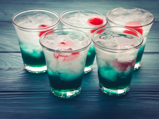 Short alcohol green drinks with cherry and crushed ice. Christmas Saint Patrick day holiday shot