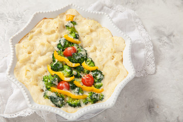 Vegetarian gratin with broccoli, cauliflower, tomato and pepper for Christmas