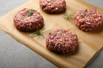 Handmade raw minced beef steak burgers on paper