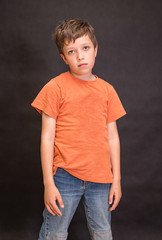 A boy portrait, young little cute and adorable kid, little obstreperous scamp. Poses, face expressions, ease, having fun, black background.
