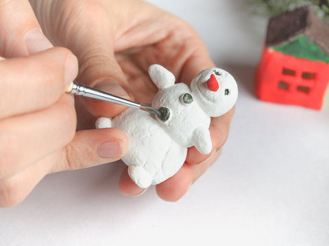 Handmade manufacture of a small toy snowman. Preparations for the celebration of Christmas.
