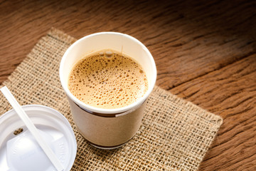 Paper cup of coffee on wood board