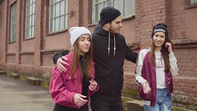 Young hipster company of three best friends having fun in urban background