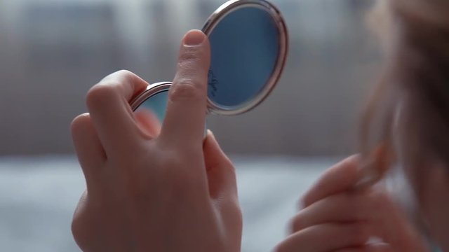 beautiful girl doing makeup in the bedroom