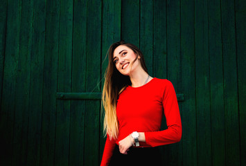 sincere smile of a girl with long hair dressed in a red sweater