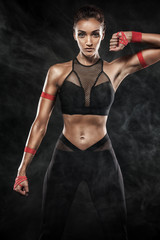 A strong athletic, woman on black background wearing in the sportswear, fitness and sport motivation.