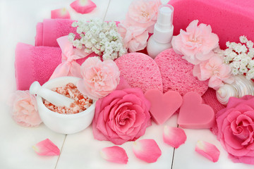 Ex foliation beauty skincare treatment products with Himalayan ex foliating salt, heart shaped soap, body scrub, body lotion, sponges, wash cloths, pink carnation flowers and decorative seashells.  