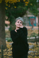 portrait of a young women standing in park on autumn day 