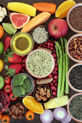 Health and super food concept to promote fitness and a healthy heart with fruit, vegetables, nuts, seeds, grains an pulses. Foods high in omega 3, antioxidants, vitamins and smart carbohydrates.