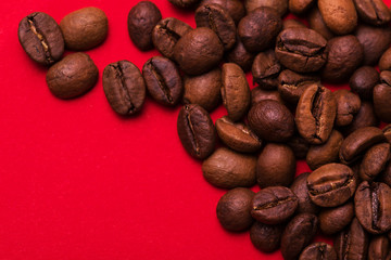 Roasted coffee beans on red background. Color surge trend.
