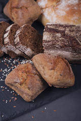 Assortment of baked bread on dark background.