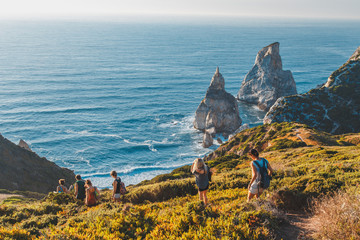 The view from the steep slope of the cliff on the secret beach, hidden among the rocks of Cape Roca, Sintra, Portugal. - obrazy, fototapety, plakaty