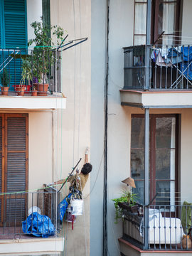 Maler streicht die Fassade an Seilen hängend