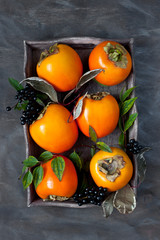 Persimmon on wooden table in rustic style, top view © amberto4ka