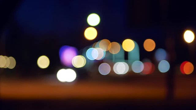 Defocused lights of moving cars. Night Traffic in the city with blurred motion. The bokeh effect. Light car bokeh moving on the road.