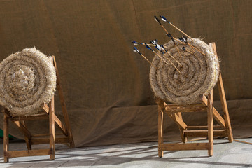 Traditional feathered arrows in traditional ancient medieval straw practice archery targets,...