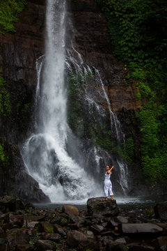 Woman posing near Gitgit waterfall on Bali in indonesia