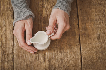 pitcher with cream in the hands