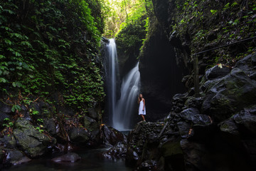 Woman posing near Gitgit waterfall on Bali in indonesia
