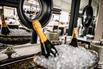 Champagne bottles in a metal bucket on a wedding table - obrazy, fototapety, plakaty