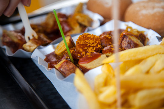 Mann isst Currywurst und Pommes Mayo in Fu&szlig;g&auml;ngerzone