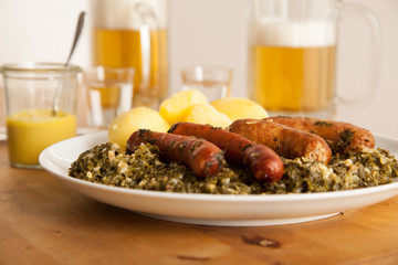 Oldenburger Grünkohl mit Pinkel, Kohlwurst und Kartoffeln dazu Bier und Korn