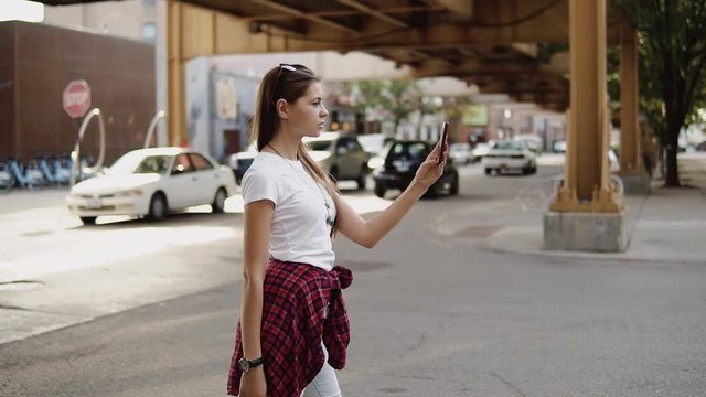 young woman walking in the city and looking for gps navigation on her phone