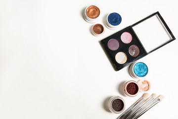 Professional makeup palette, cream eyeshadow and brushes on a white background. Space for text