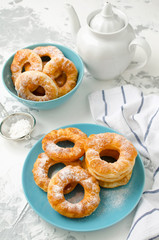 Homemade fried vanilla cottage cheese donuts on a white concrete background
