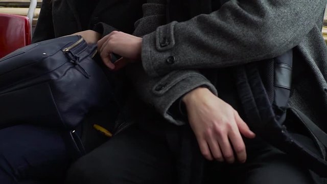 Pickpocket stealing phone from a woman's handbag in tram or bus