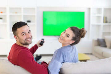 Young couple on the sofa watching television