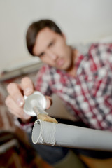Man applying glue to end of pvc pipe