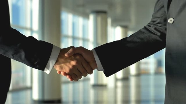 The two businessmen handshake. slow motion