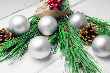 Christmas gift box and branch christmas tree and silver ball and cone on white wooden rustic background