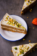 Paleo raw vegan pistachio carrot cake with cashew cream layers. Dark food photography concept