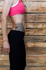 Gymnast in a pink crop top with a beautiful tatoo on her side