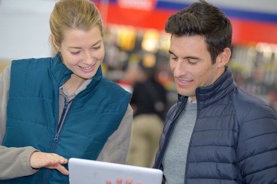 male customer showing digital tablet to female vendor