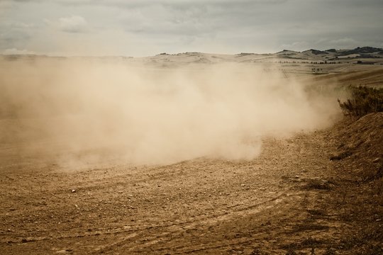 carretera de tierra con una nube de polvo despues de pasar un vehiculo