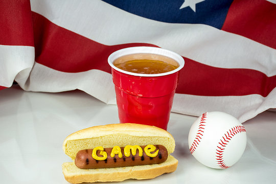 Word Game Written In Mustard On Hot Dog With Beer Cup And Baseball And American Flag Background